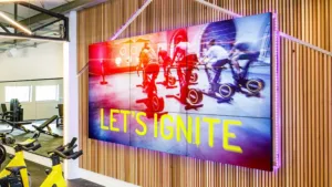 Indoor advertising display screen in gym showcasing fitness content