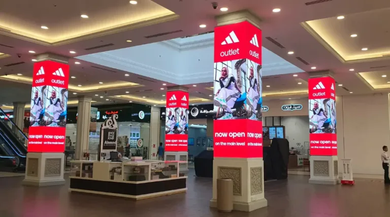 Four pillar LED displays in mall showing brand advertisements