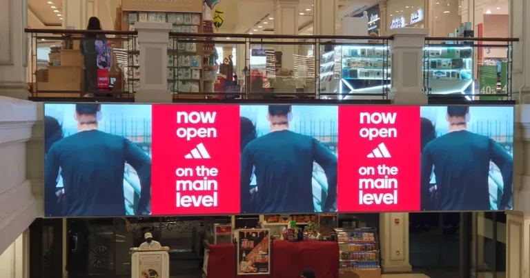 Large mall screen displaying shop opening advertisement