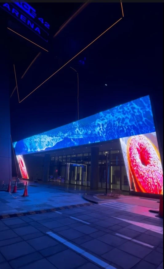Colorful billboard showcasing donut glowing at night