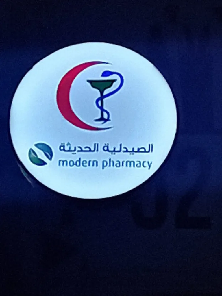 Round light box sign for Modern Pharmacy in Arabic and English