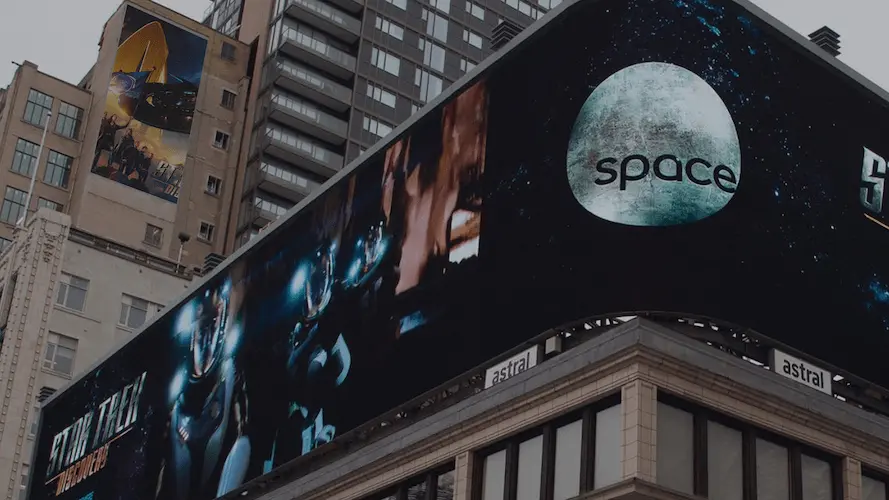 Outdoor digital screen displaying rocket visuals for space missions