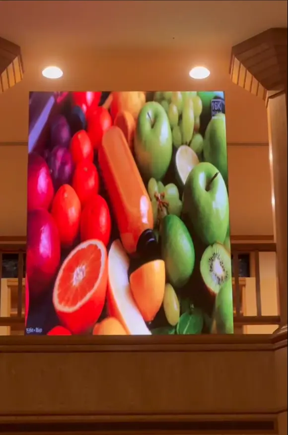 Indoor LED screen on wall displaying assorted fruits and vegetables
