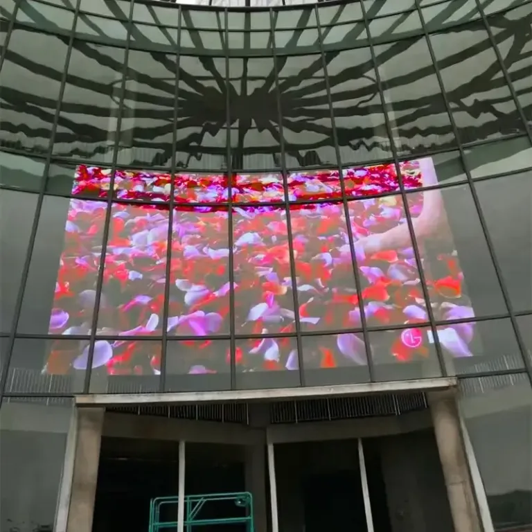 Outdoor transparent LED display showing vibrant flowers in modern building