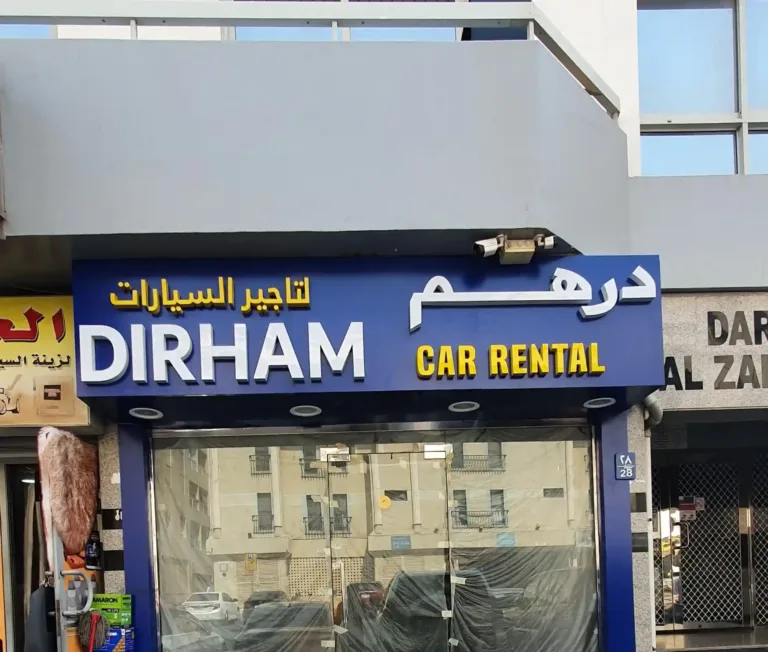 Exterior of car rental shop with 3D sign reading 'Dirham'
