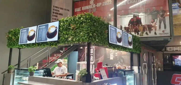 Man at restaurant counter with LCD menu displays in background