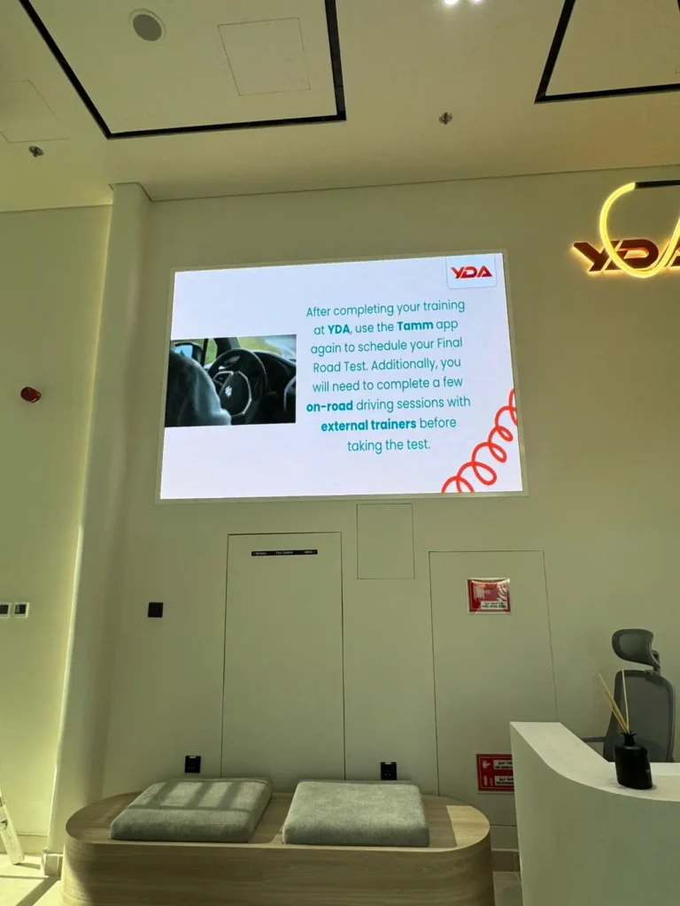 Indoor LED screen displaying driving academy content in lobby