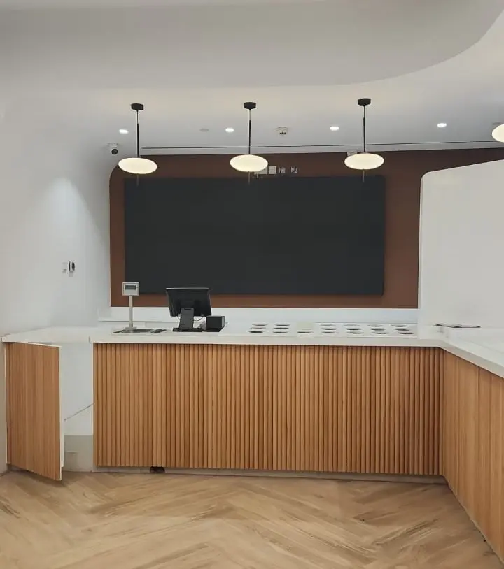 Indoor area with wooden floors and wall-mounted LED screen near counter