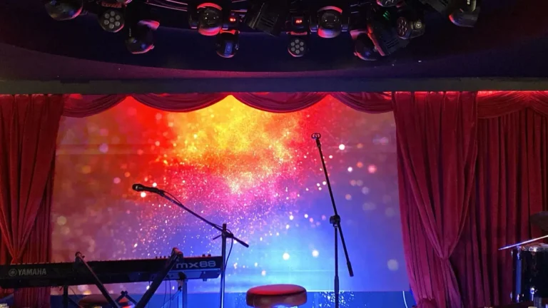 Indoor stage with red curtains and LED screen for presentation